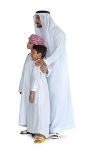 arab man with his two sons in traditional clothing standing and looking