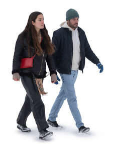 two cut out people walking on a snowy street in winter