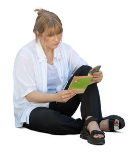 woman sitting on the ground and reading a book