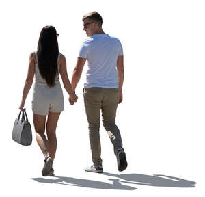 backlit couple walking hand in hand