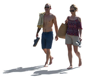 backlit man and woman walking barefoot in resort