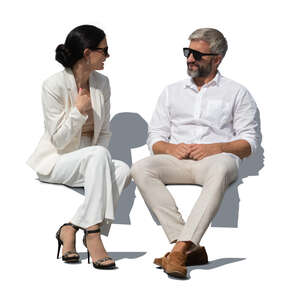 man and woman in white outfits sitting and talking