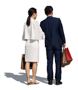 asian couple with shopping bags standing in front of the shop window