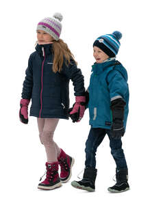 two kids walking happily hand in hand in winter