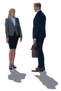 two backlit business people standing and talking