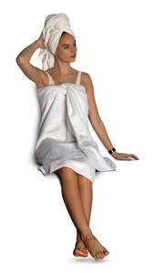 cut out woman in a white spa towel sitting in a sauna