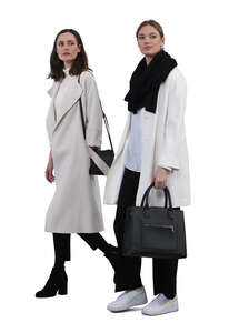 two cut out women wearing light overcoats walking together