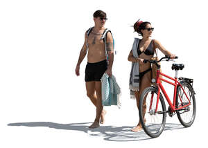 man and woman with a bike going to the beach