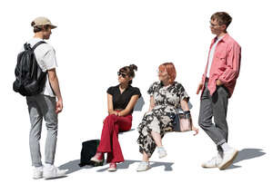 two boys standing and talking to two girls sitting