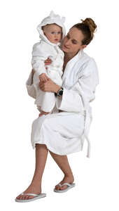 woman and her baby son in white bathrobes sitting