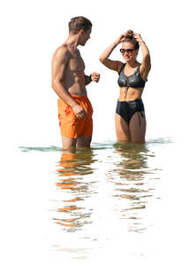young man and woman standing in the water at the beach