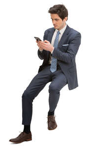 man in a suit sitting on a barstool