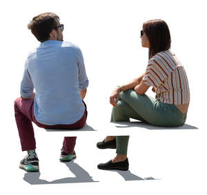 two backlit people sitting seen from back angle