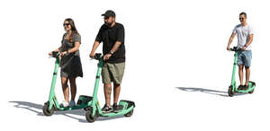 group of three people riding on electric scooters