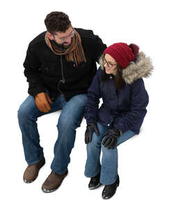 man and woman in winter sitting seen from above