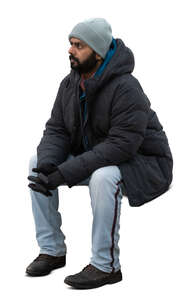 indian man in winter jacket sitting