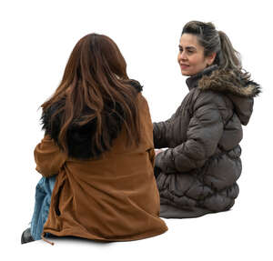two women wearing warm jackets sitting and talking