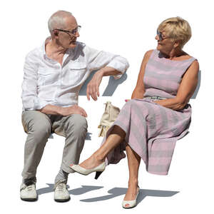 two senior citizens sitting and talking outside in summer