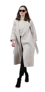 woman in a white overcoat walking