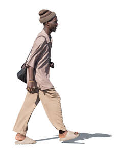 black man in light brown outfit walking