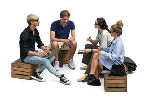 group of young people sitting on wooden crates