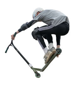 boy with a scooter doing tricks in skatepark