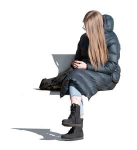 woman in a puffy overcoat sitting