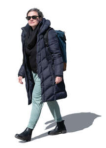 woman with a backback and sunglasses walking