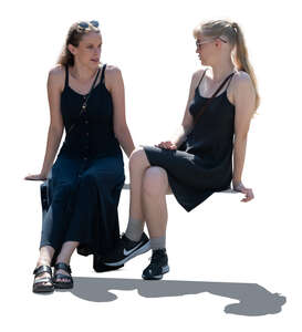 two women in black dresses sitting and talking