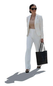backlit woman wearing a white suit walking