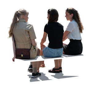 three backlit women sitting and talking