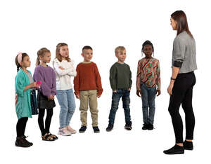 group of children standing and listening to a teacher