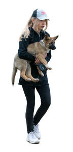 girl walking and carrying a puppy