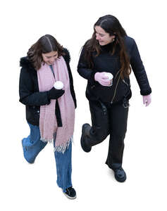 top view of two women with hot drinks walking in winter