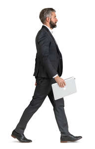 man in a suit and carrying a laptop walking