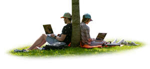 two people with computers sitting under a tree