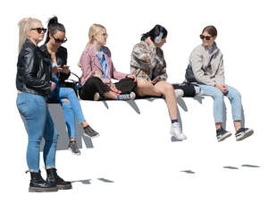 group of teenage girls sitting on a street balustrade