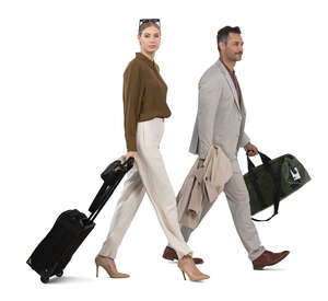 elegant man and woman with suitcases walking