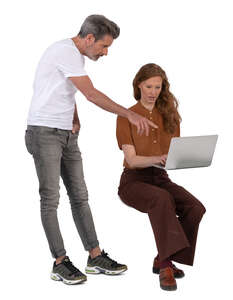 man standing and talking to a woman working with computer