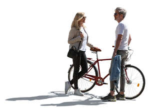 backlit man and woman with a bike standing