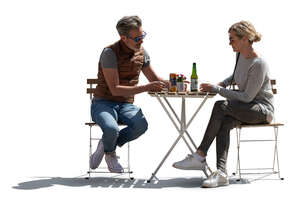 backlit man and woman sitting in an outdoor restaurant