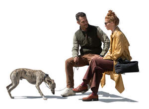 man and woman with a dog sitting and talking