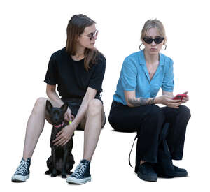 two women and a dog sitting and talking