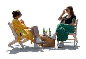 backlit image of two women sitting in a garden cafe