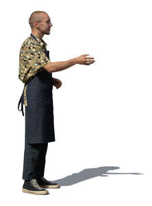man with apron standing and greeting somebody