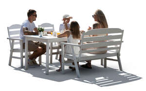 backlit family sitting in a garden by a table and eating  