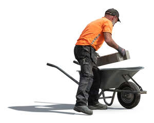 workman loading bricks into wheelbarrow