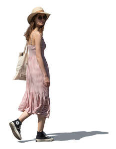 woman in a summer dress and wearing a hat walking