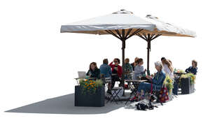 backlit street cafe with parasols and people