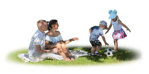 family with kids sitting on the grass in the tree shade